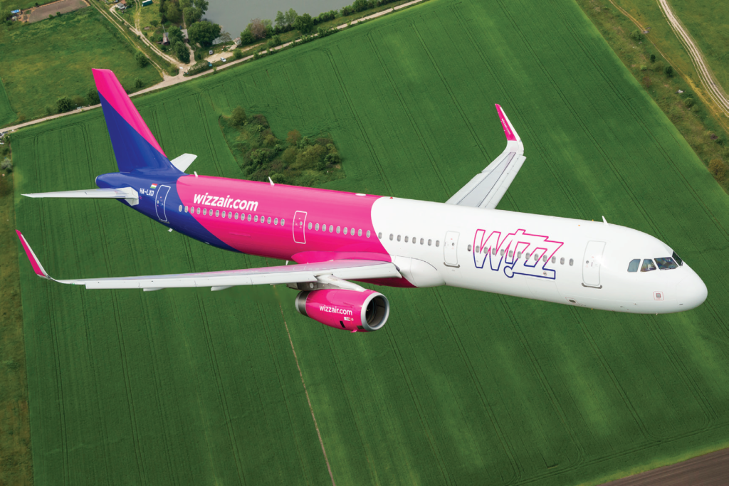 Wizz Air airplane in the air over fields